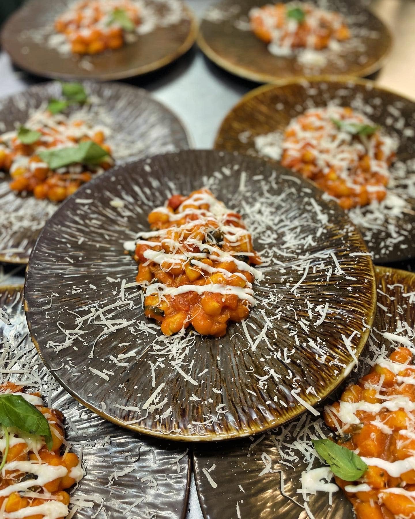 Piatti di gnocchi al pomodoro impiattati in cucina