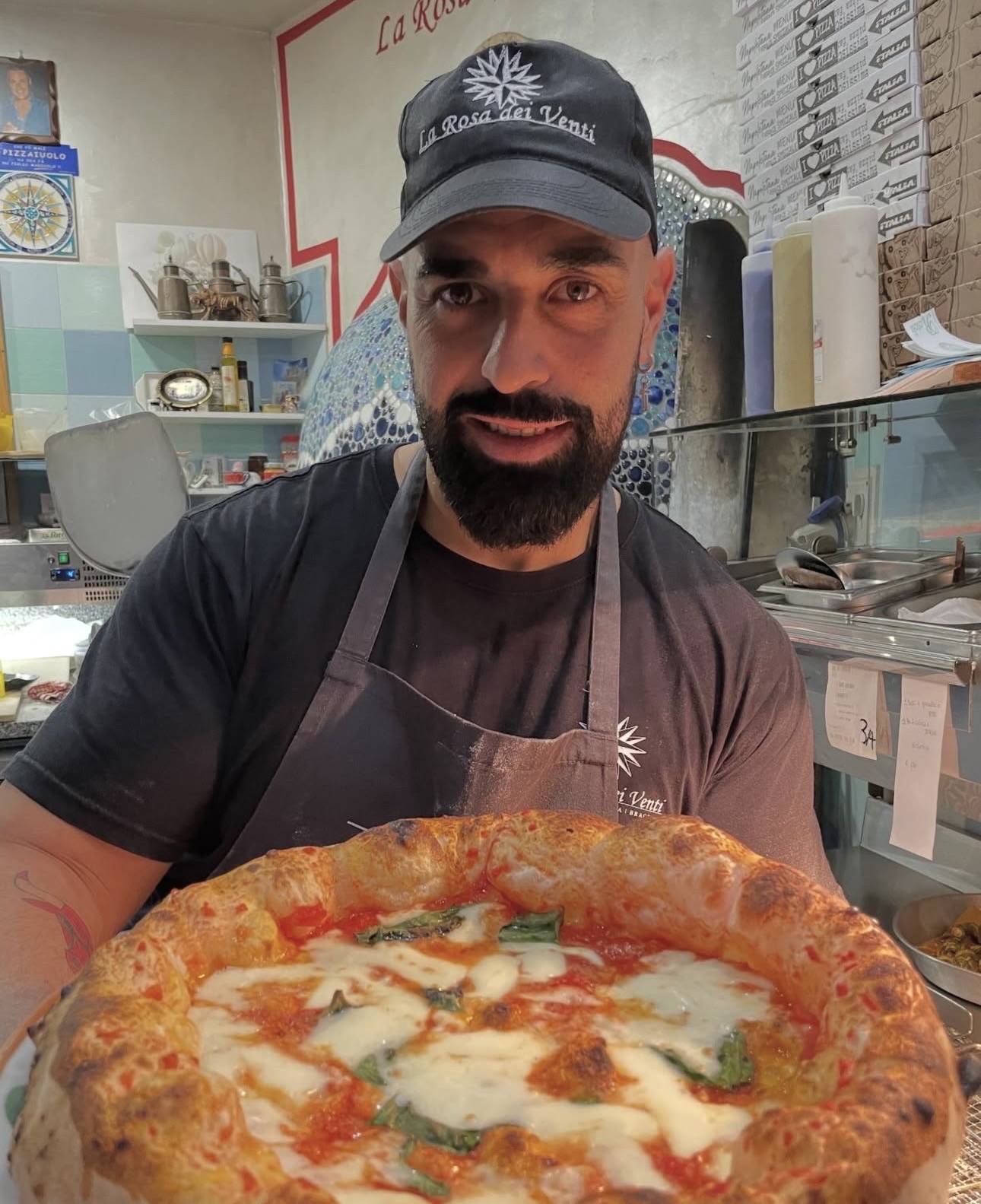 Il pizzaiolo della Rosa dei Venti con una margherita appena sfornata